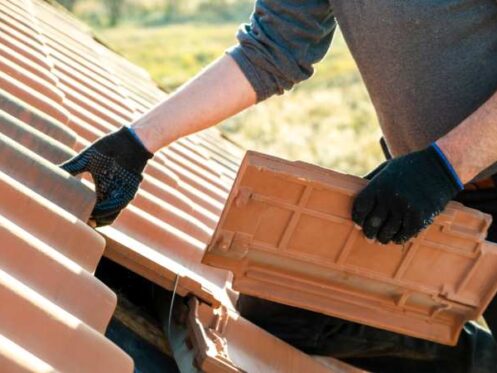 a man doing roofing upgrades by replacing the existing ones.